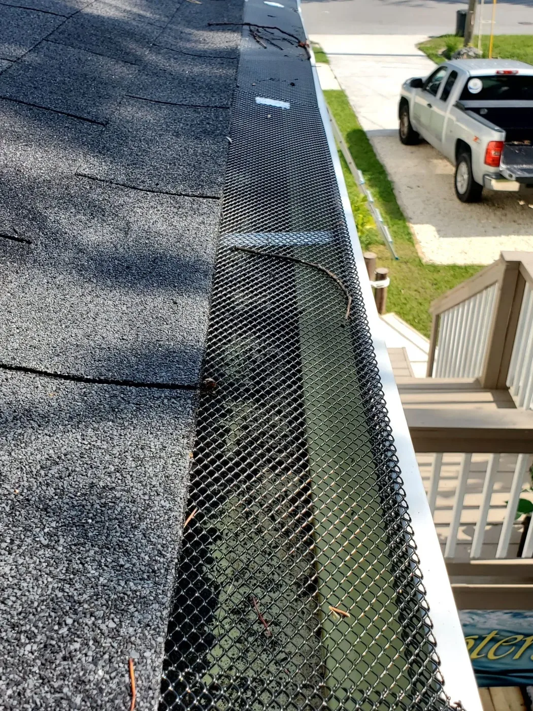 Black micro-mesh gutter guard running clean along a home's roofline