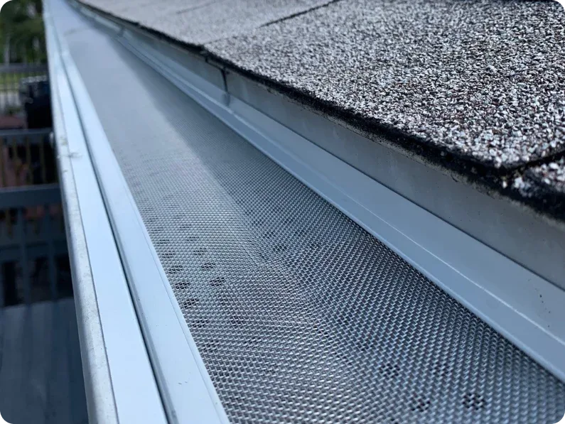 Close-up of stainless micro-mesh gutter guard installed over a gutter to keep debris out
