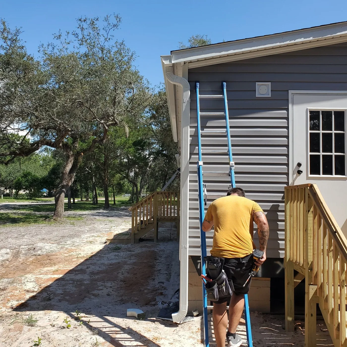 A Rain Storm Solutions installer on a ladder fitting a seamless gutter