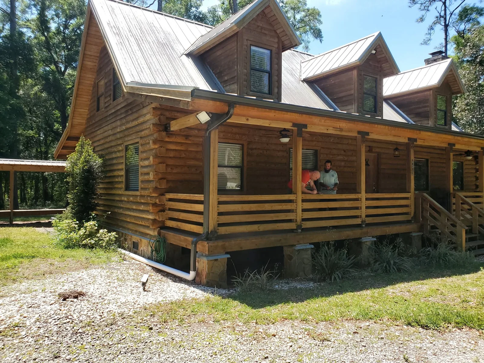A log-cabin-style home with new seamless gutters and a metal roof