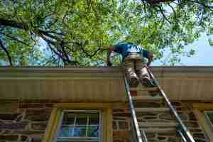 Cleaning gutter on ladder