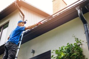 Gutter technician installing new gutters on a residential home Florida. Talk to our preofessionals who know how long it takes to install gutters.
