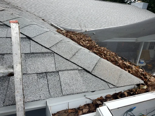 Gutter cleaning by Rain Storm Solutions technicians. The ladder is proppoed up against the house to clear the debris from the gutter.